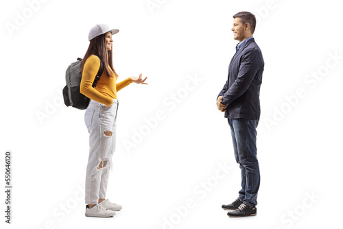 Full length profile shot of a female student with a backpack talking to a man