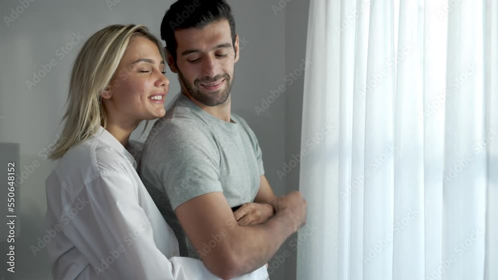 Caucasian couple spending together at home, Husband happily hugs and smiles at his wife. Caucasian couple spending together at home, Husband happily hugs and smiles at his wife.