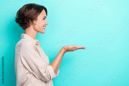 Profile photo of attractive pretty girlish business lady toothy smile hold palms please give me new gift empty space isolated on aquamarine color background photo