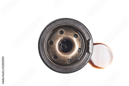 Car oil filter with a puddle of engine oil isolated on white background