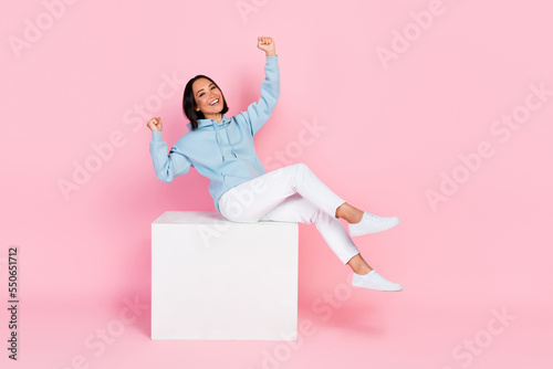 Photo of overjoyed joyful lady wear trendy clothes raise hands fists glad triumph yes hooray empty space isolated on pink color background