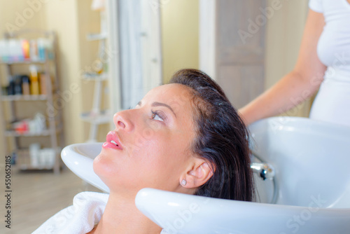 Hairdresser washing a woman's hair photo