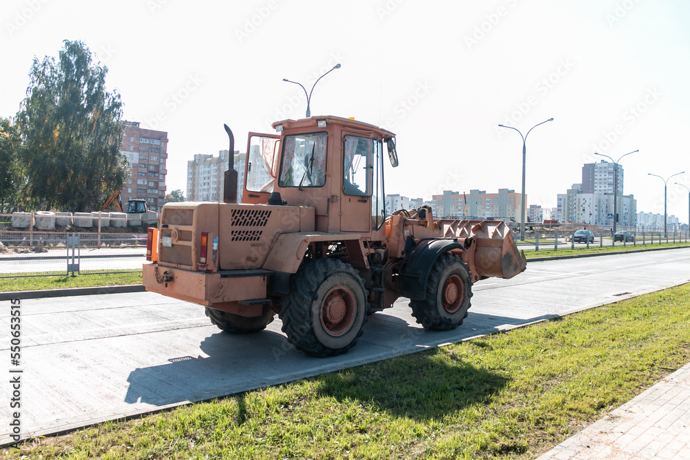 A wheeled bulldozer is conducting road construction work in the city.