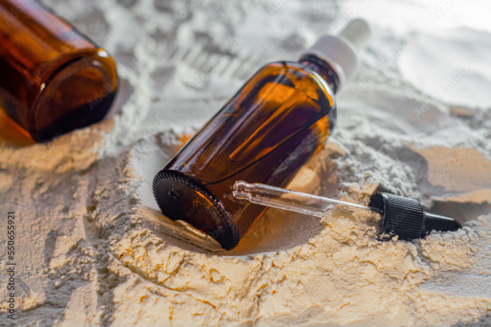 Natural cosmetics face oil in brown bottle on the sand