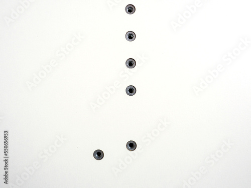 Screws screwed into the white surface. Furniture fittings