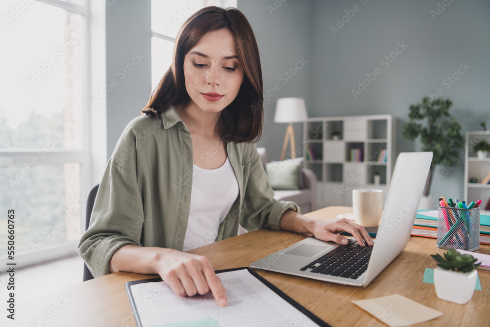 Portrait of smart focused lawyer girl sitting chair finger point read document paper use netbook modern office inside