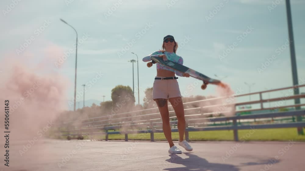 Girl skateboarder spinning longboard with smoke