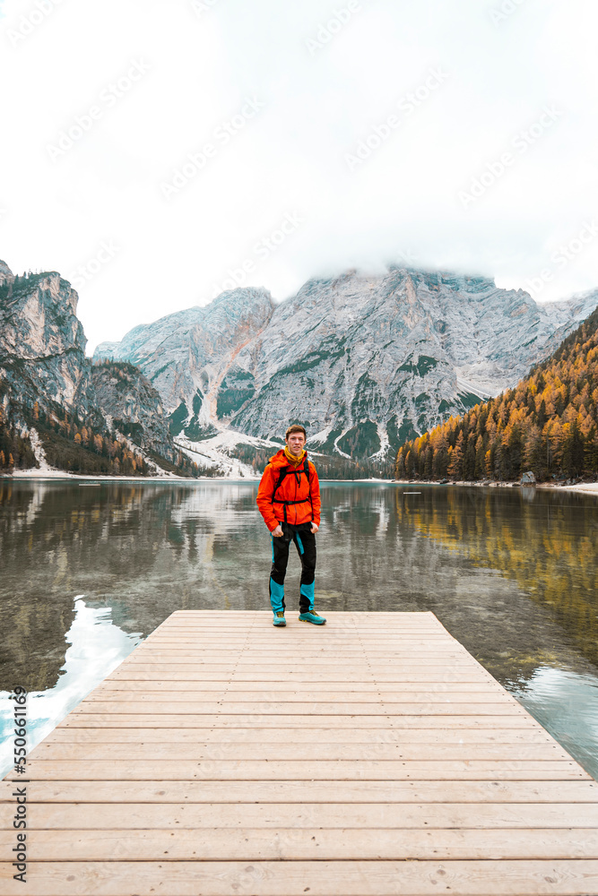 person on the pier with mountains and lake in background
