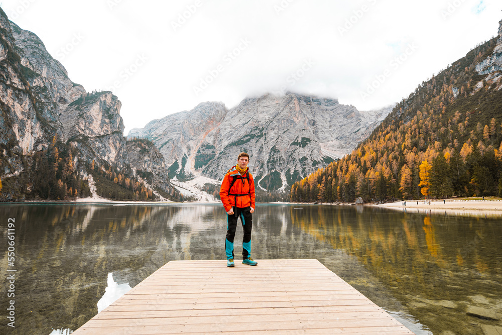 person on the pier with mountains and lake in background in dolomites
