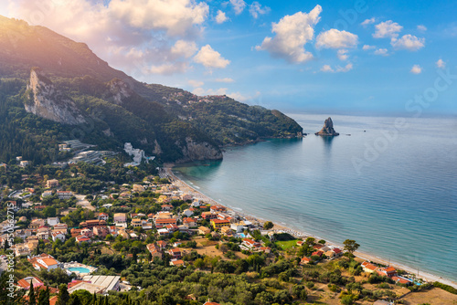 Agios Gordios exotic beach in Corfu island Greece. Agios Gordios beach  Corfu island  Greece. Panoramic view of the Agios Gordios beach  sandy seashore with beach umbrellas and deck chairs.