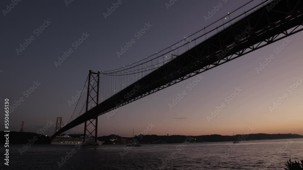Late sunset landscape of a big tourist ship sailing under the bridge Late sunset landscape of a big tourist ship sailing under the bridge