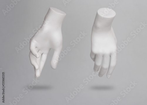 White mannequin hands levitating on gray background with shadow