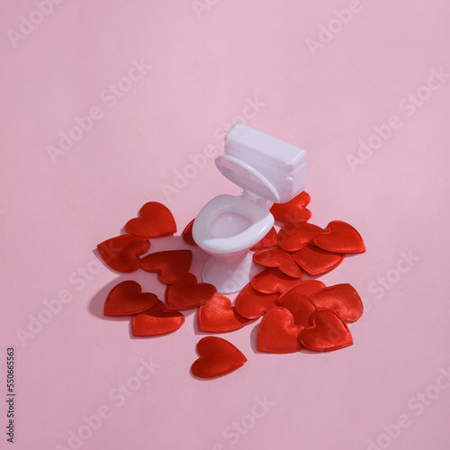 Toilet model with hearts on a pink background. Love concept, valentine's day, february 14th celebration, creative layout