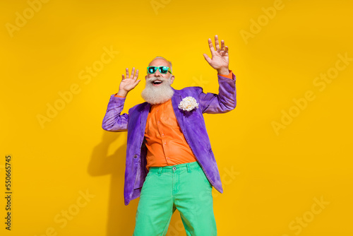 Photo portrait of attractive grandpa nightclub dancer retro vintage festive wear trendy colorful look isolated on yellow color background