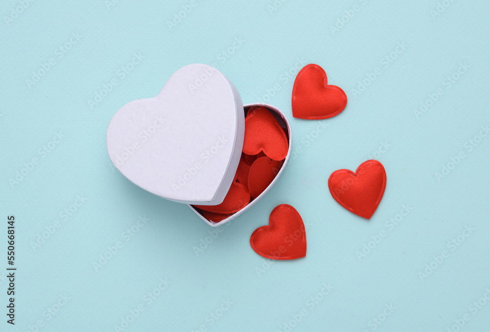 White box with hearts on blue background. Love concept, valentine's day, february 14th celebration, top view White box with hearts on blue background. Love concept, valentine's day, february 14th celebration, top view