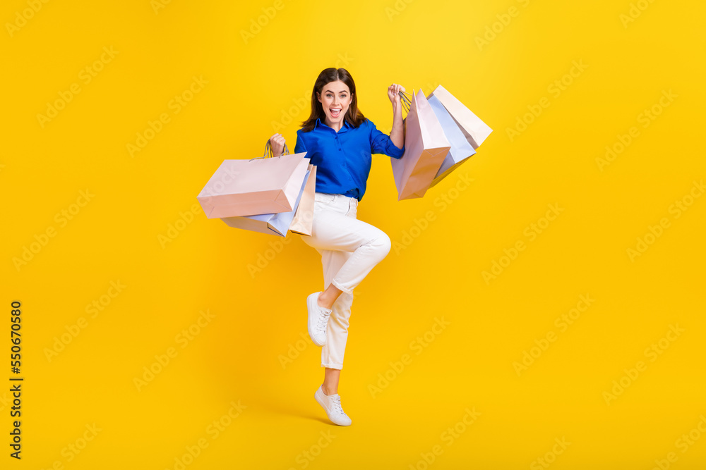 Φωτογραφία Full length photo of lucky excited girl dressed blue shirt jumping high holding