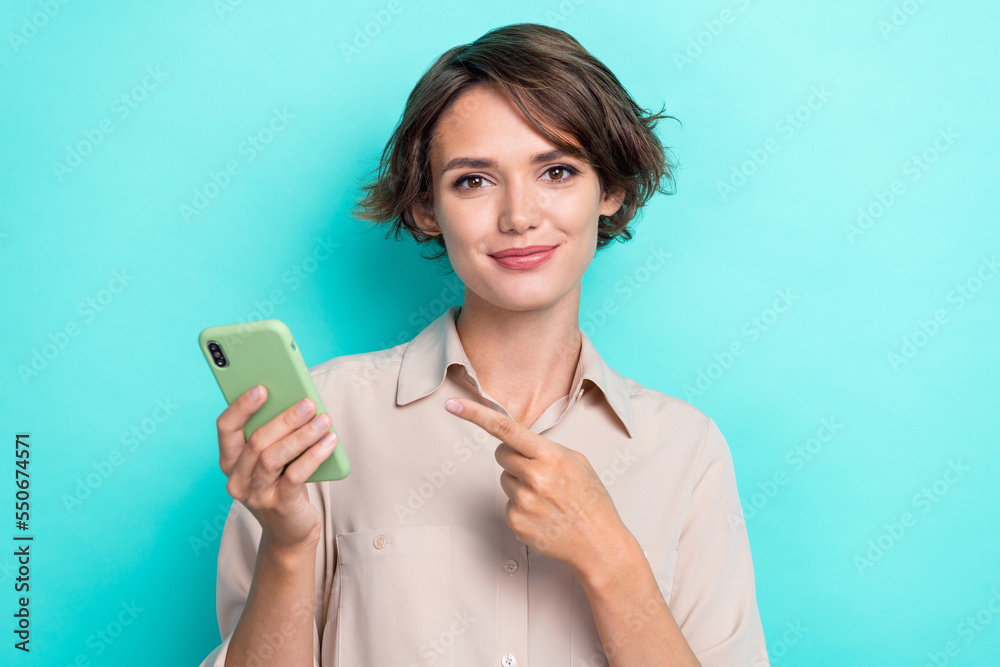 Photo of adorable positive lovely nice woman bob hairdo dressed beige blouse hold indicating phone isolated on teal color background Photo of adorable positive lovely nice woman bob hairdo dressed beige blouse hold indicating phone isolated on teal color background