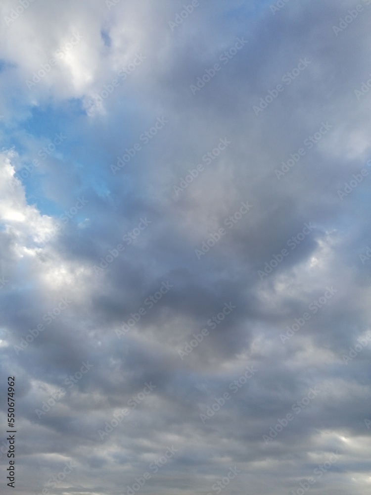 Fondo natural con detalle de nubes en tonos blancos y grises, sobre cielo azul