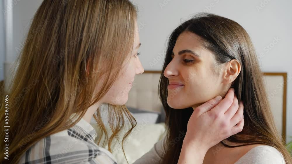 Lesbian women touch noses and kiss on cheeks smiling Lesbian women touch noses and kiss on cheeks smiling