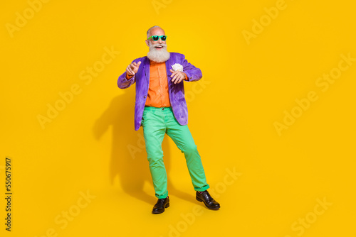 Full body photo of attractive grandpa have fun dancing enjoy disco rhythm wear trendy colorful garment isolated on yellow color background