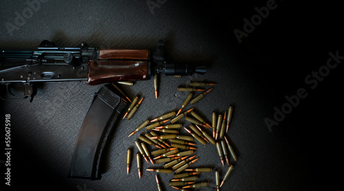 An assault rifle, weapons with a cartridges on a dark background. photo