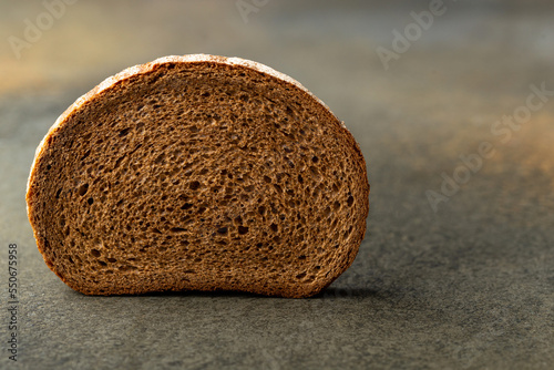 Slice of fresh rye bread on greybackground photo