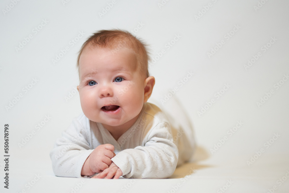 portrait of an infant lying on his back against a white background portrait of an infant lying on his back against a white background