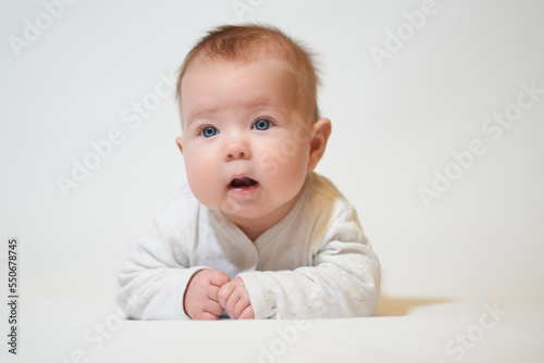 Portrait of an infant with its mouth open against a white background