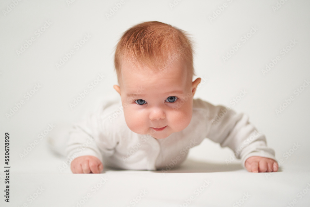 portrait of an infant lying on his back with a sly emotion on a white background portrait of an infant lying on his back with a sly emotion on a white background