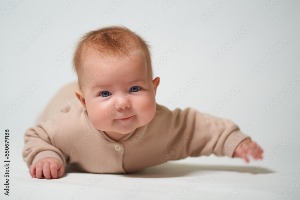 Portrait of an infant learning to crawl on a white background Portrait of an infant learning to crawl on a white background