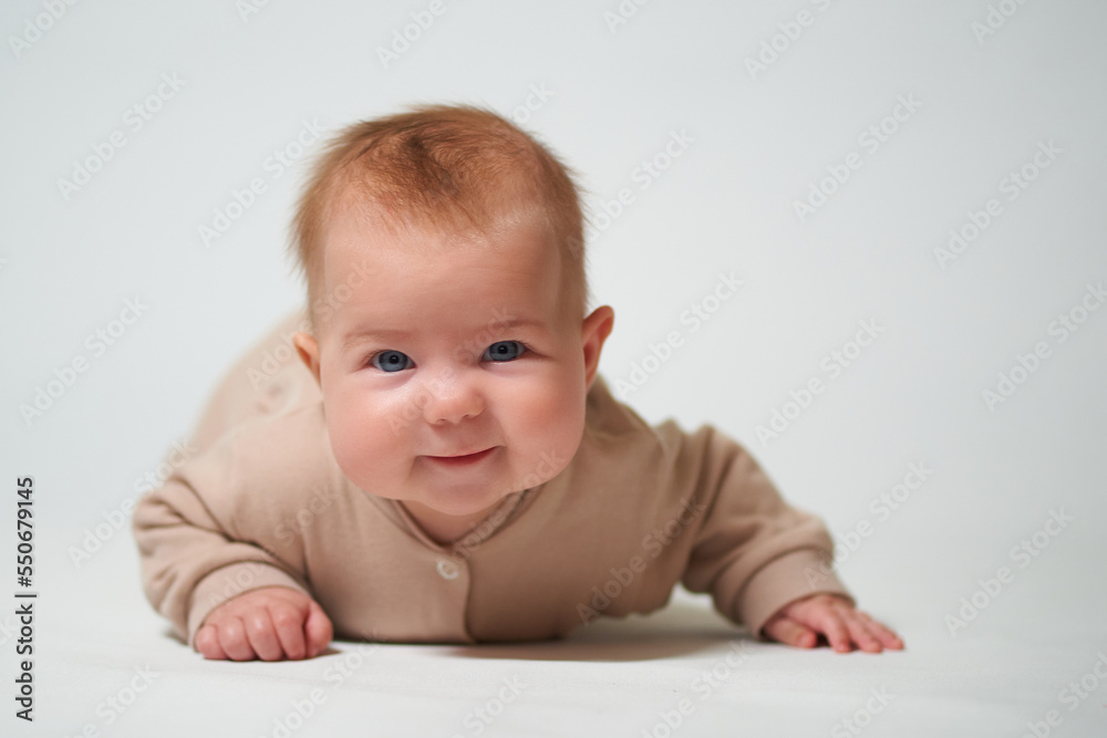 Portrait of an infant learning to crawl on a white background Portrait of an infant learning to crawl on a white background
