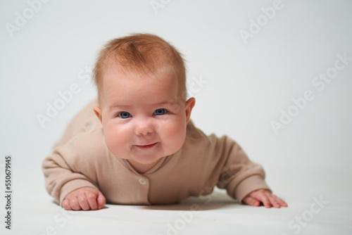 Portrait of an infant learning to crawl on a white background