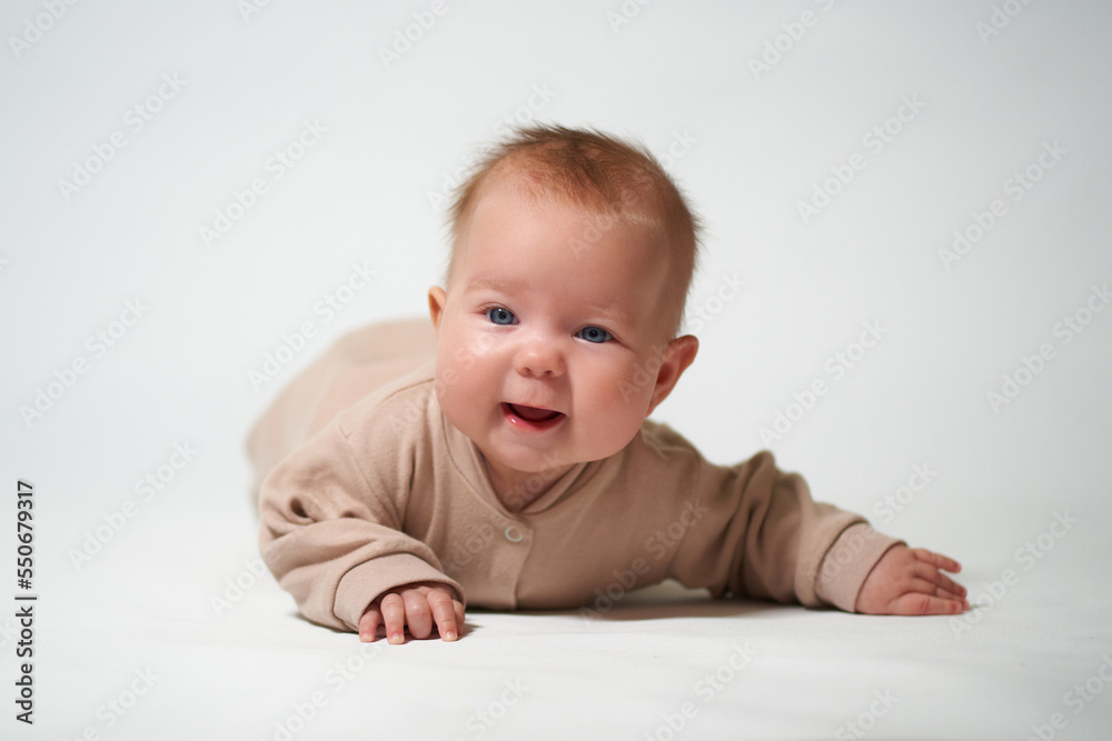 portrait of an infant looking into the camera who is learning to crawl on a white background portrait of an infant looking into the camera who is learning to crawl on a white background
