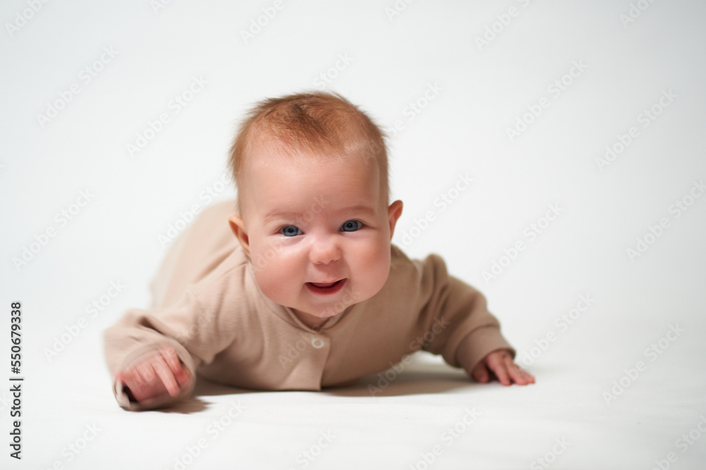 portrait of an infant looking into the camera who is learning to crawl on a white background portrait of an infant looking into the camera who is learning to crawl on a white background