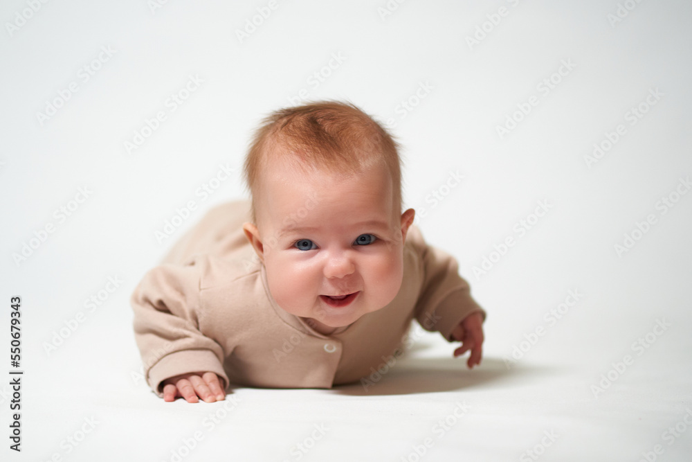 portrait of an infant looking into the camera who is learning to crawl on a white background portrait of an infant looking into the camera who is learning to crawl on a white background