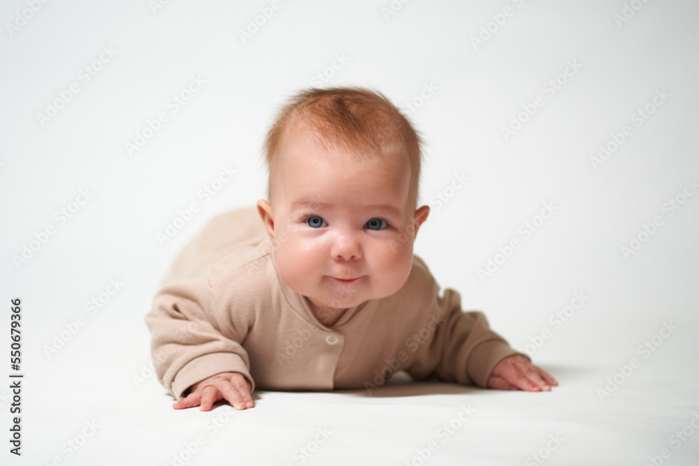 portrait of an infant looking into the camera who is learning to crawl on a white background portrait of an infant looking into the camera who is learning to crawl on a white background