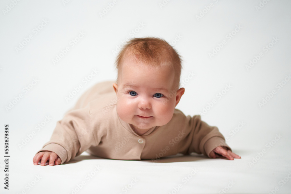 portrait of an infant learning to crawl against a white background portrait of an infant learning to crawl against a white background