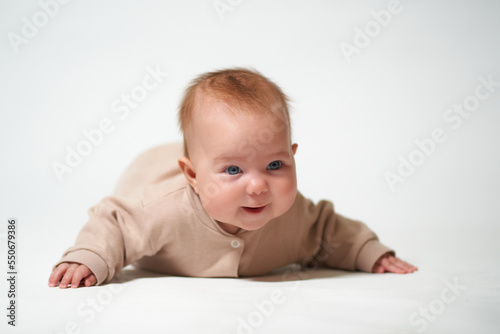 portrait of an infant learning to crawl against a white background