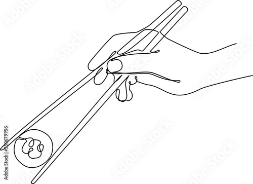 Hand with chopsticks holding sushi roll