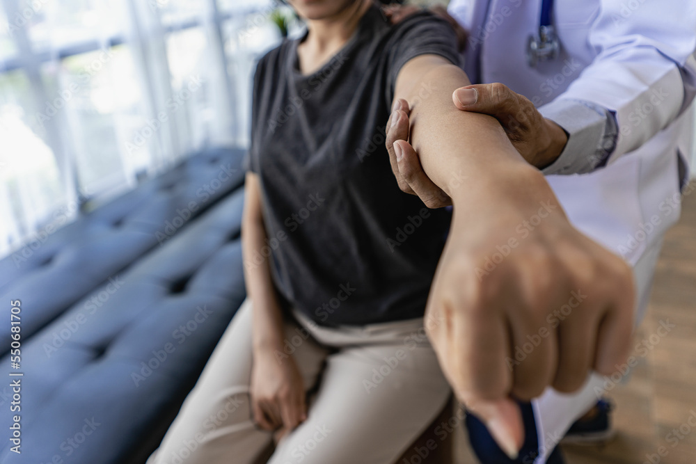 Fototapeta premium Male therapist treating injured shoulder on female athlete's shoulder Post traumatic muscle rehabilitation, sports physiotherapy, recovery concept.