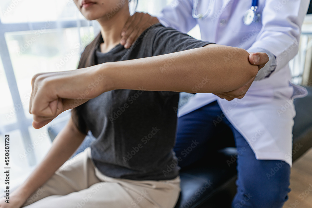 Obraz premium Male therapist treating injured shoulder on female athlete's shoulder Post traumatic muscle rehabilitation, sports physiotherapy, recovery concept.
