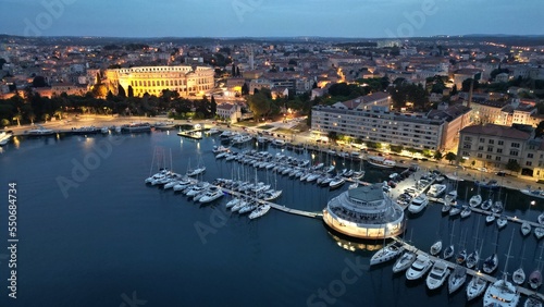 town harbour Pula with roman amphitheatre at night  aerial view