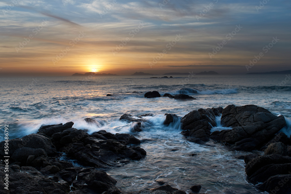 Sunset over the beach with large rocks Sunset over the beach with large rocks