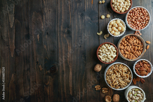 Nuts variety in the bowls - cashew, hazelnut, macadamia, pistachio, almond, walnut, peanut, pecan