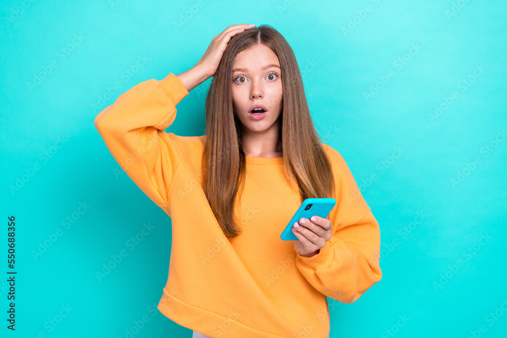 Photo of young funny stressed nervous little girl touch head forgot her email password new smartphone isolated on aquamarine color background Photo of young funny stressed nervous little girl touch head forgot her email password new smartphone isolated on aquamarine color background
