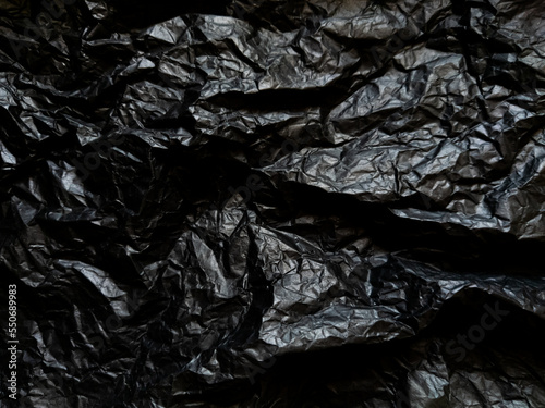 Crumpled black paper with texture. Dark black textured background © Gustavo