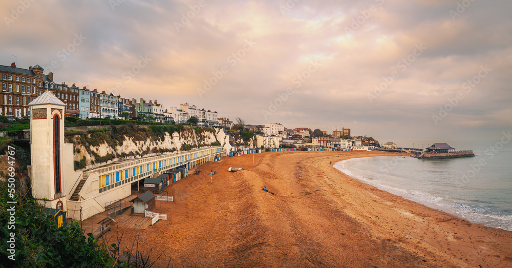Panoramic image of Viking Bay, Broadstairs, UK on a mild winter day. The elevator shaft to the beach and the row of beach huts can be seen along with the pier.