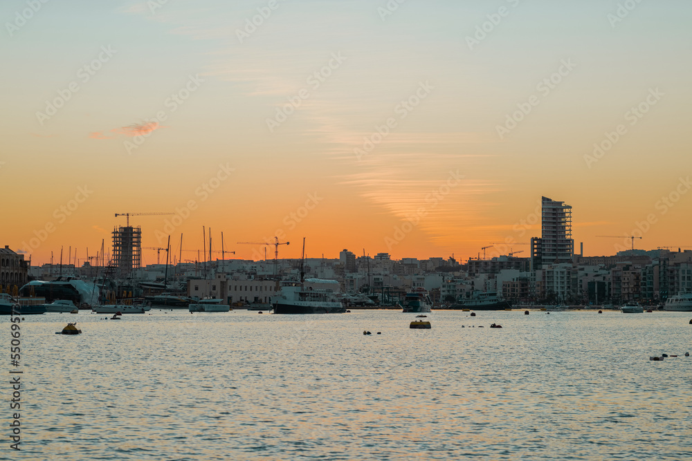 Cityscape of Il-gzira waterfront between valletta and sliema on malta island on autumn evening, with picturesque sunset.