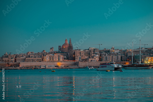 Cityscape of Valletta, Malta on an autumn evening in golden hour or blue hour. Nice panorama with still water and lights in the city.