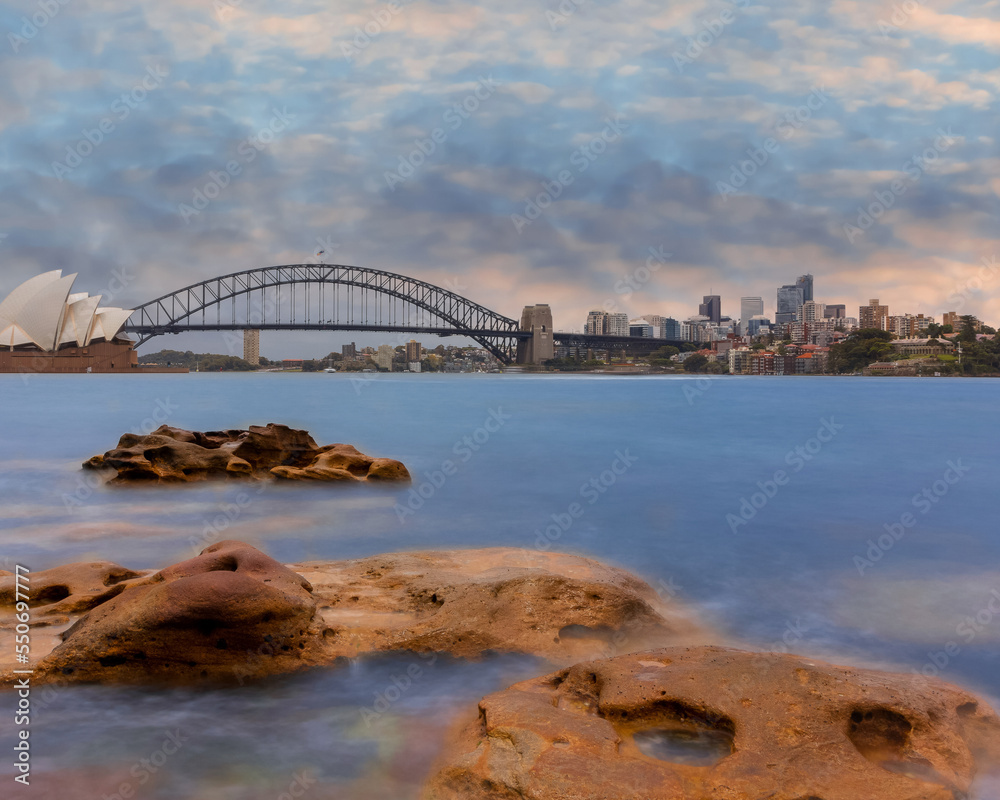 Naklejka premium Sydney Harbour Australia at Sunset with the turquoise colours of the bay and high rise offices of the City in the background
